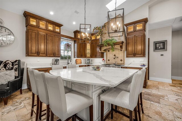 kitchen featuring stone tile flooring, a kitchen island, and baseboards