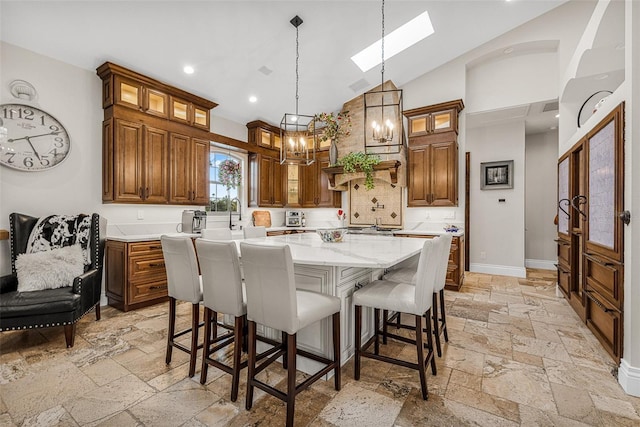 kitchen with stone tile flooring, a kitchen breakfast bar, a center island, and baseboards