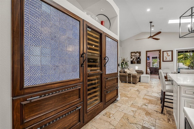 entryway with lofted ceiling, a ceiling fan, and stone tile flooring