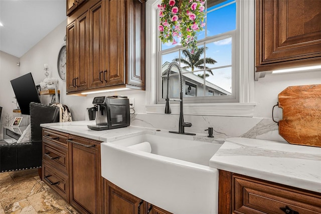 kitchen with a sink, brown cabinets, and lofted ceiling