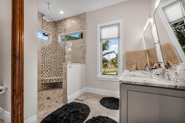 full bath featuring vanity, a walk in shower, and baseboards