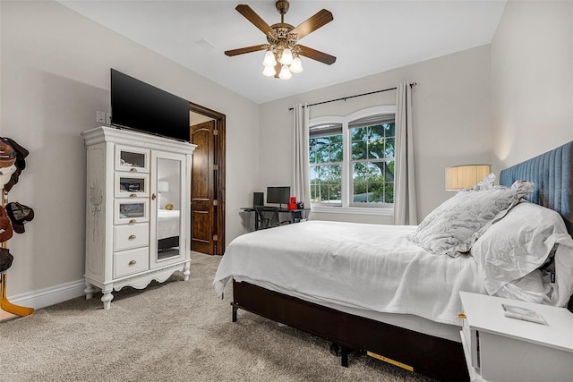 bedroom featuring baseboards, light carpet, and a ceiling fan