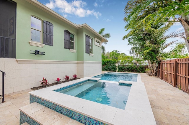 view of pool featuring an in ground hot tub, a fenced backyard, and a patio