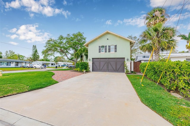 view of front of property featuring a garage, stucco siding, driveway, and a front yard