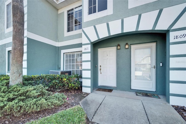 doorway to property featuring stucco siding