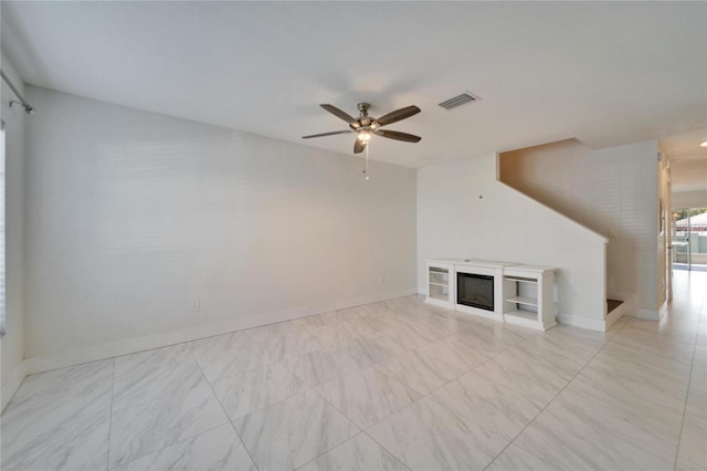 unfurnished living room featuring visible vents, baseboards, a ceiling fan, and a glass covered fireplace