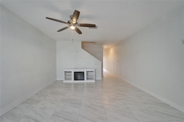 unfurnished living room with a glass covered fireplace, ceiling fan, baseboards, and visible vents