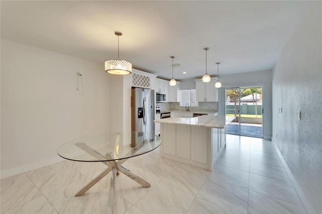 kitchen featuring decorative light fixtures, tasteful backsplash, white cabinetry, stainless steel appliances, and baseboards