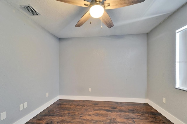 unfurnished room with dark wood finished floors, visible vents, a ceiling fan, and baseboards