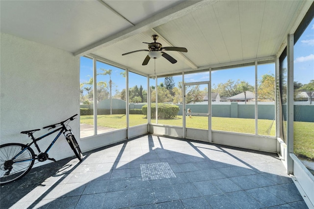 unfurnished sunroom featuring a healthy amount of sunlight and ceiling fan