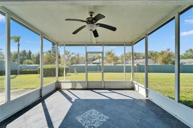 unfurnished sunroom featuring a wealth of natural light and a ceiling fan