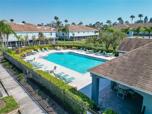 pool with a patio area and fence