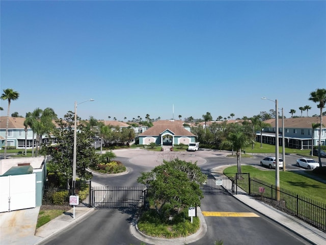 view of street with curbs, a gated entry, street lighting, and a gate