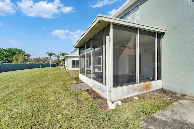 view of property exterior featuring a yard, a sunroom, and stucco siding