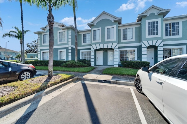 view of property featuring stucco siding and uncovered parking