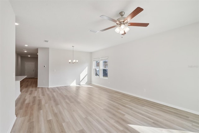 unfurnished living room with visible vents, ceiling fan with notable chandelier, baseboards, and light wood finished floors