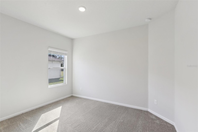 carpeted empty room featuring recessed lighting and baseboards