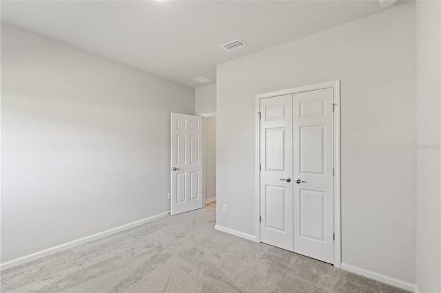 unfurnished bedroom featuring a closet, visible vents, baseboards, and carpet floors