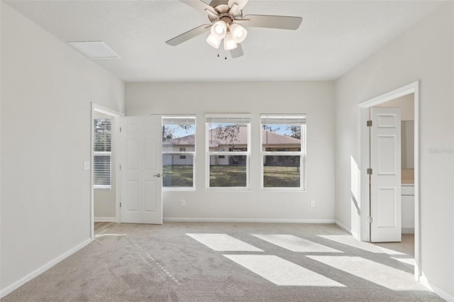 empty room with visible vents, light colored carpet, baseboards, and ceiling fan