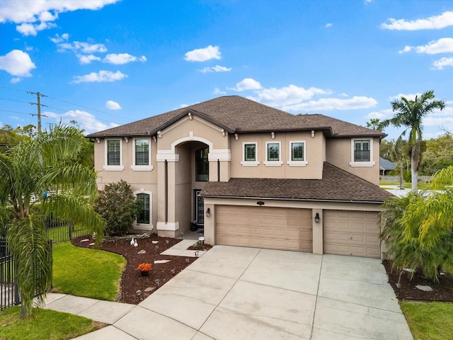 view of front of home featuring a shingled roof, fence, a garage, and stucco siding