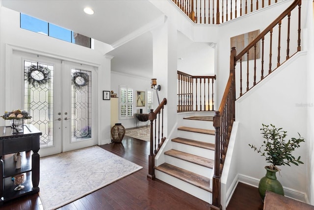 entrance foyer featuring french doors, wood-type flooring, baseboards, and a towering ceiling