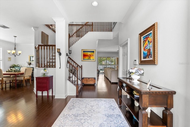 entryway with visible vents, ornamental molding, wood finished floors, stairway, and a chandelier