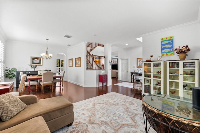 living area featuring crown molding, stairs, an inviting chandelier, and wood finished floors