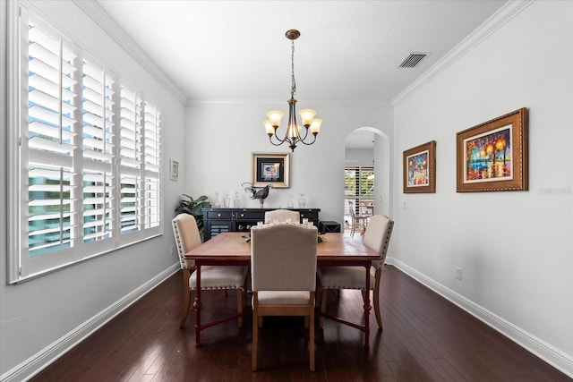 dining room featuring dark wood finished floors, visible vents, baseboards, and arched walkways