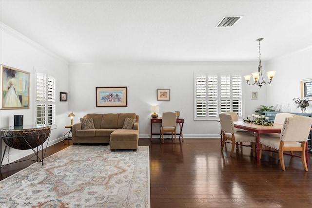 living area featuring a chandelier, plenty of natural light, ornamental molding, and hardwood / wood-style flooring