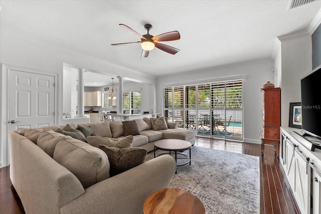 living room with visible vents, ceiling fan, ornamental molding, dark wood-style floors, and ornate columns