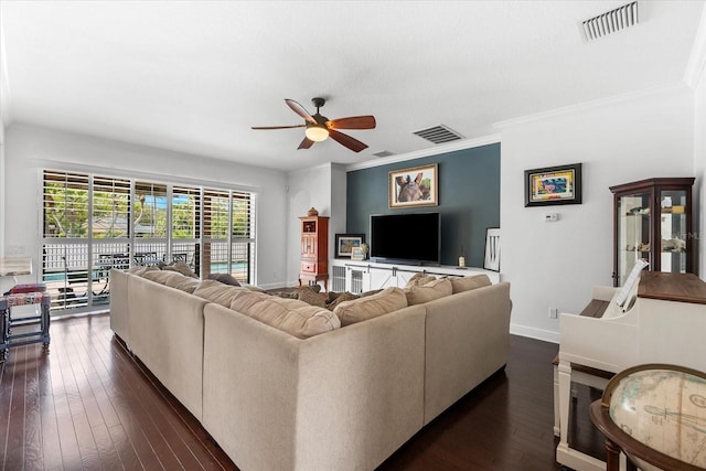 living area featuring visible vents, baseboards, dark wood-style floors, and ornamental molding