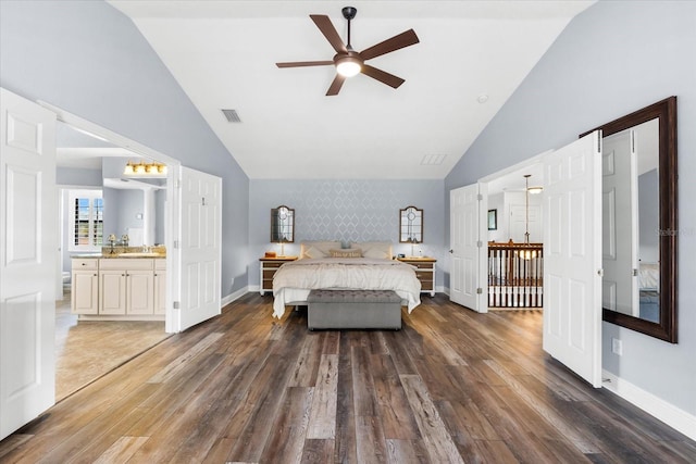 bedroom with visible vents, baseboards, wood finished floors, high vaulted ceiling, and a sink