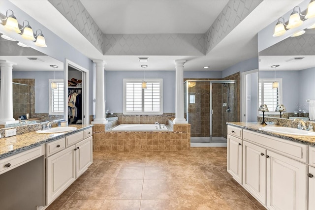 full bath with decorative columns, a bath, a stall shower, and a sink