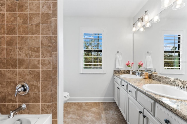 bathroom with a sink, baseboards, double vanity, and tile patterned floors