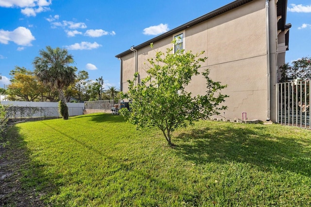 exterior space with a yard, stucco siding, and fence