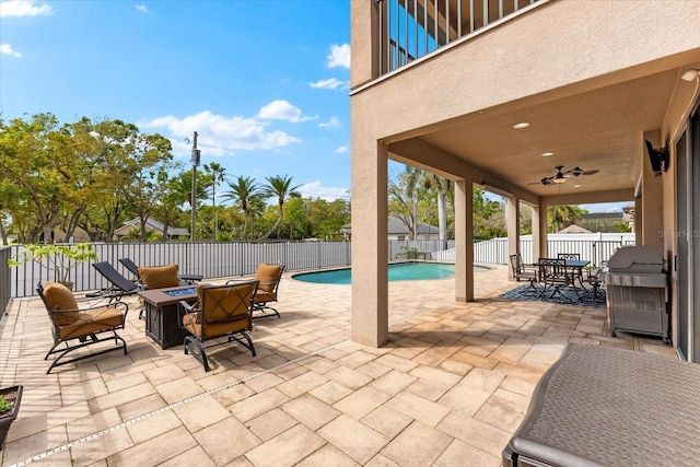 view of patio with grilling area, a fenced in pool, an outdoor fire pit, outdoor dining area, and a fenced backyard