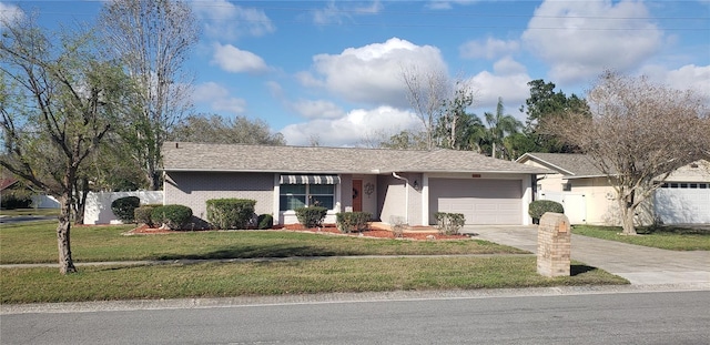 ranch-style home with fence, concrete driveway, an attached garage, a front yard, and brick siding