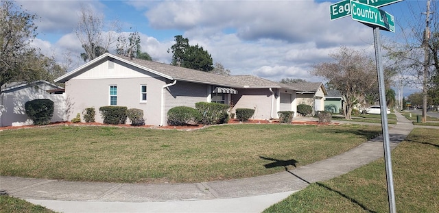 exterior space featuring a yard, brick siding, an attached garage, and a shingled roof