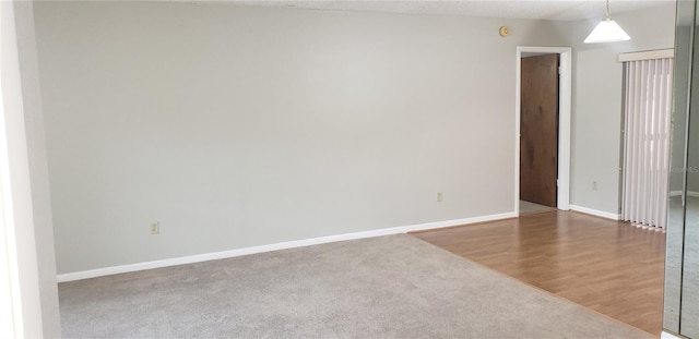 empty room with baseboards and wood finished floors