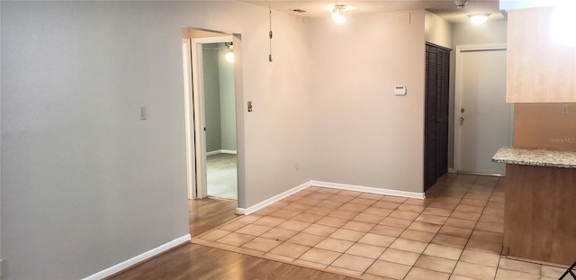 hallway featuring baseboards and light wood finished floors