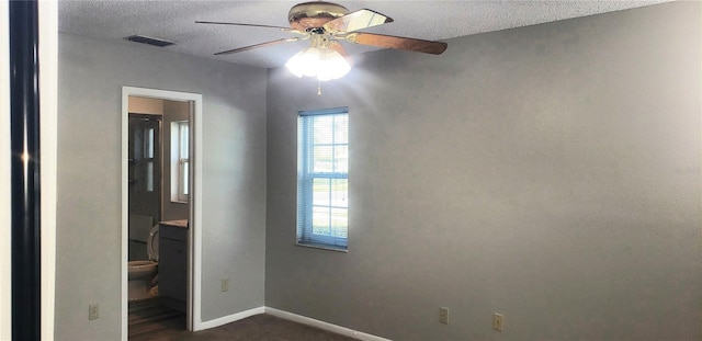 spare room with visible vents, baseboards, a textured ceiling, and a ceiling fan