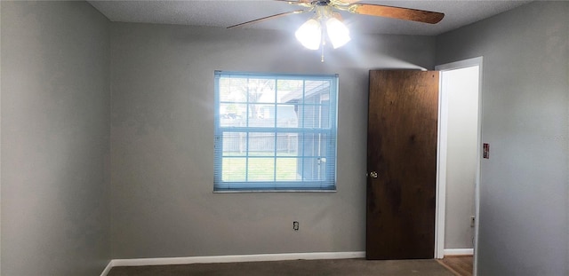 empty room featuring a wealth of natural light, baseboards, and a ceiling fan