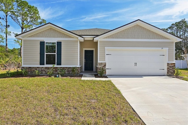 view of front of property featuring a front lawn, an attached garage, concrete driveway, and stone siding