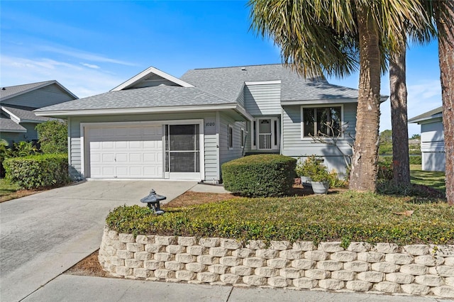 single story home with concrete driveway, a garage, and roof with shingles