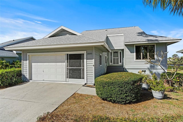 single story home with an attached garage, concrete driveway, and roof with shingles