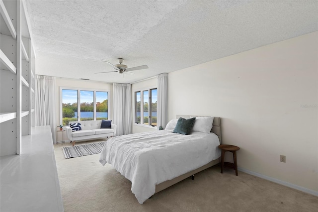 bedroom featuring baseboards, carpet flooring, a textured ceiling, and ceiling fan