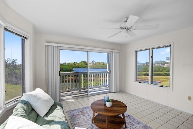 living room featuring light tile patterned floors, baseboards, and ceiling fan