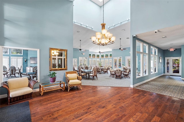 living area featuring a wealth of natural light, baseboards, wood finished floors, and ceiling fan