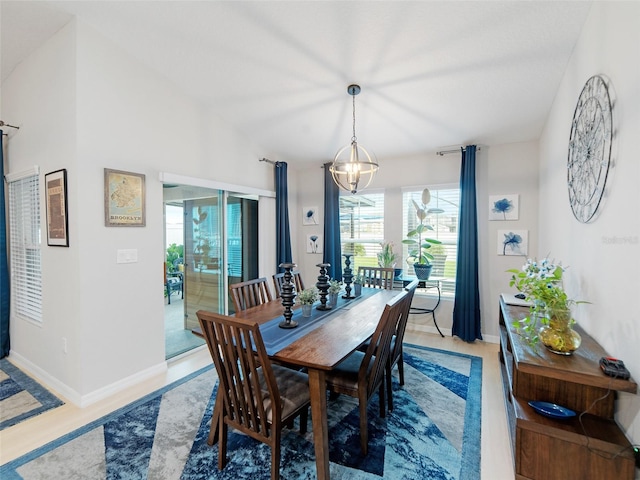 dining space featuring baseboards and a chandelier