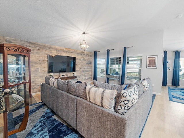 living area featuring wood finished floors, plenty of natural light, wood walls, and an accent wall